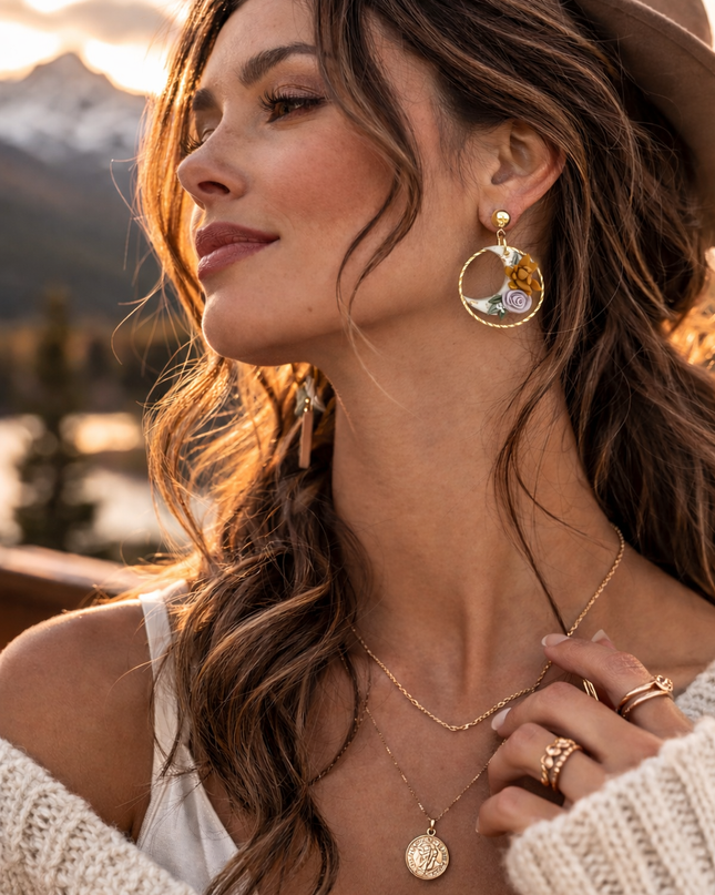 Woman wearing gold jewelry with a scenic background