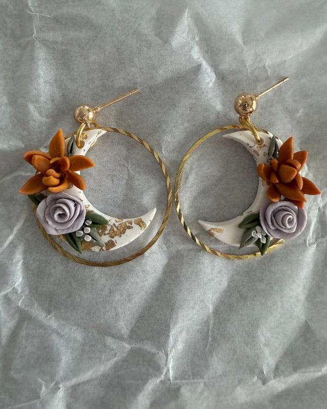 Pair of floral hoop earrings on a textured gray background