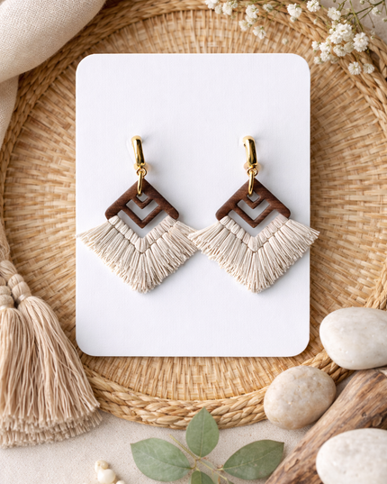 Pair of earrings on a white card with natural elements around