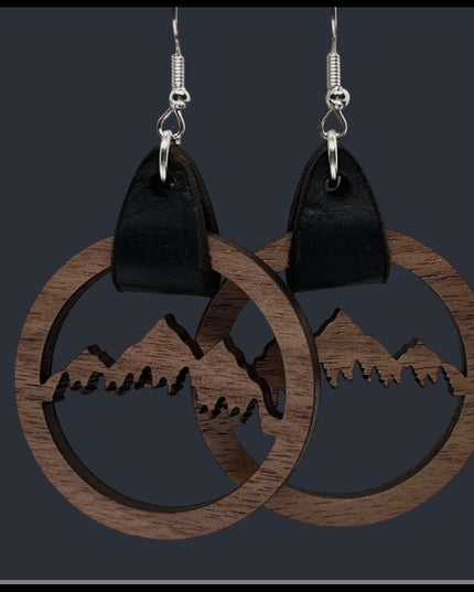 Wooden earrings with mountain design on a dark background